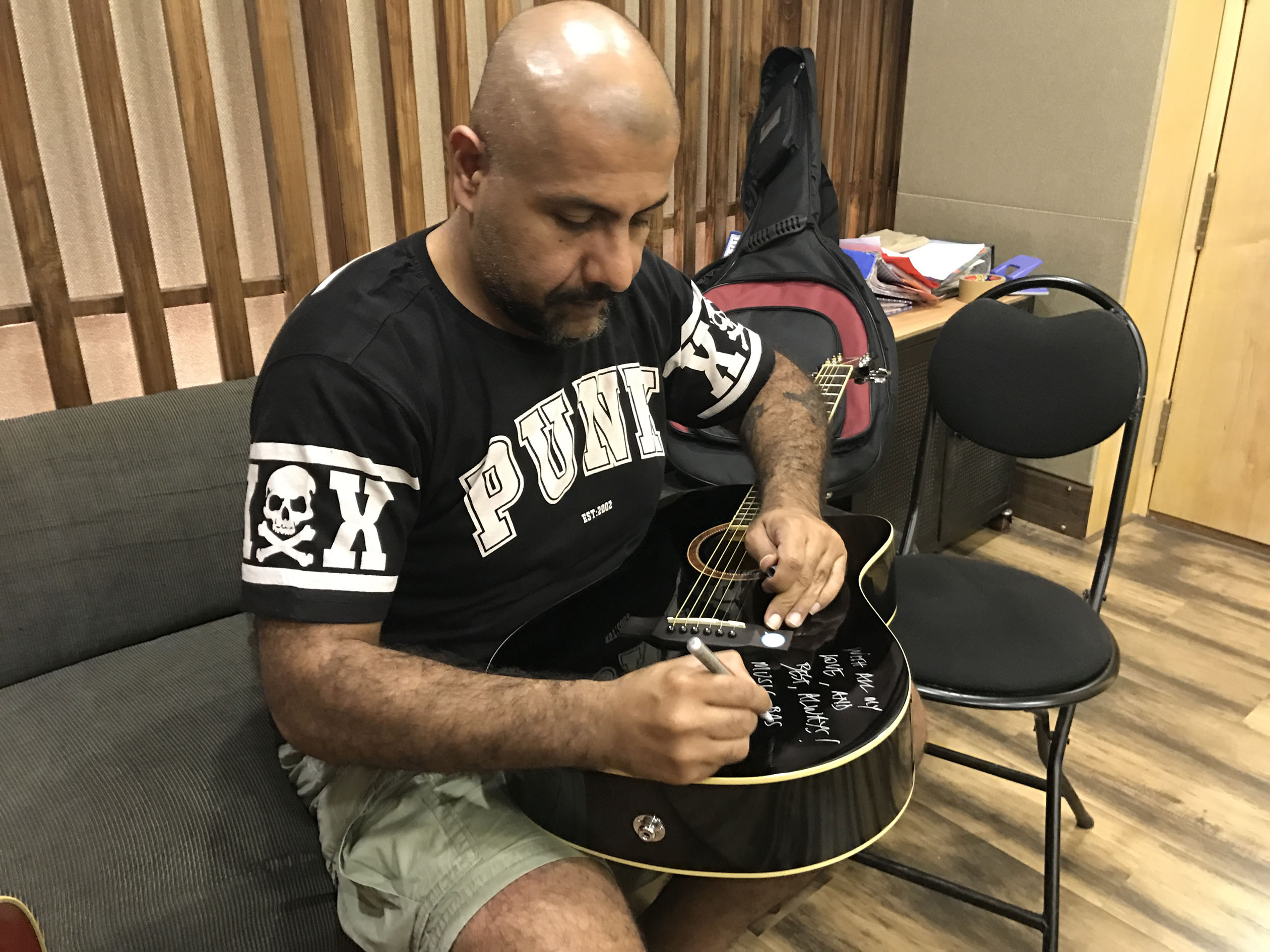 vishal-dadlani-signing-his-guitar-for-donation-for-music-for-a-cause