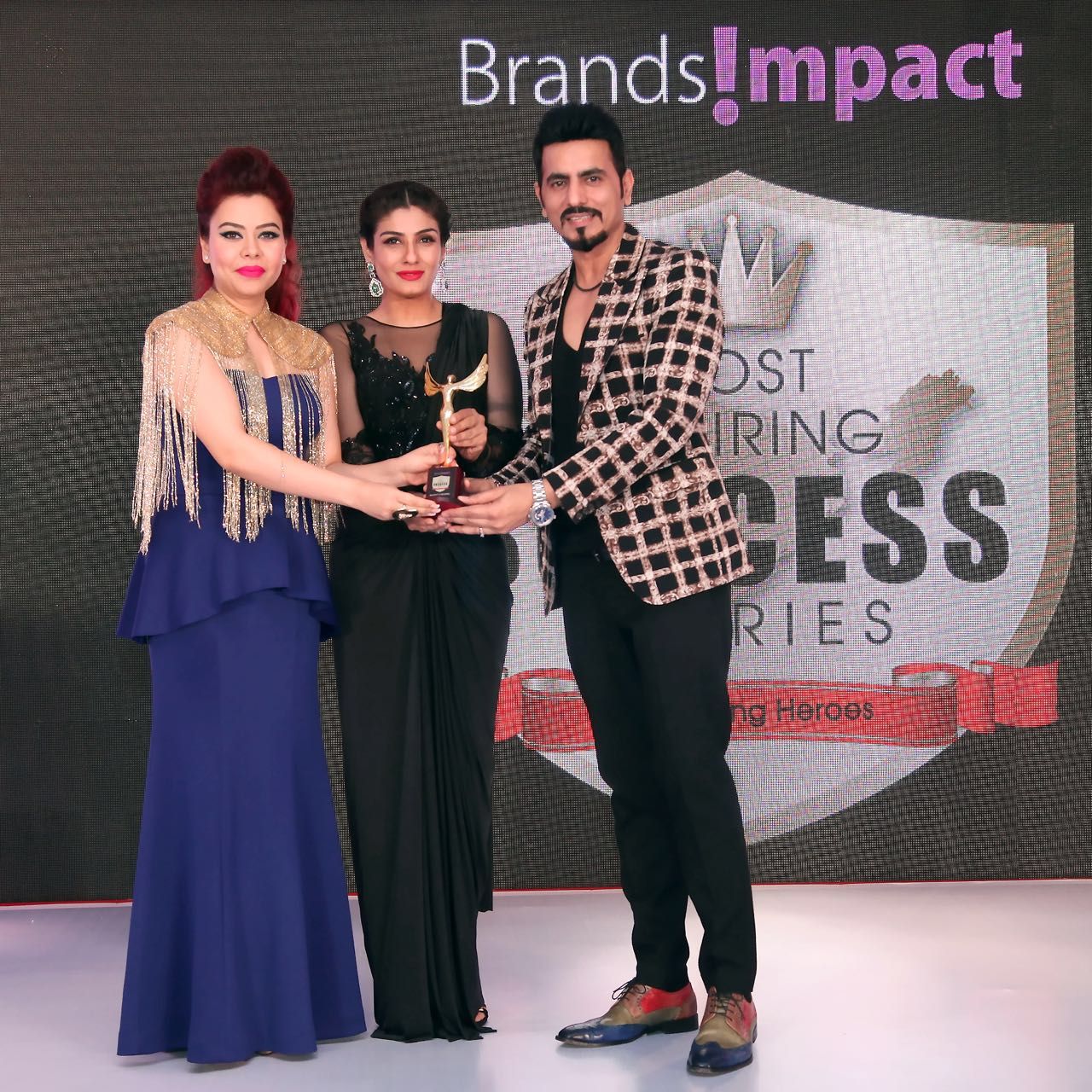 Designer Duo Bharat & Reshma Grover while receiving an award from Raveena Tandon